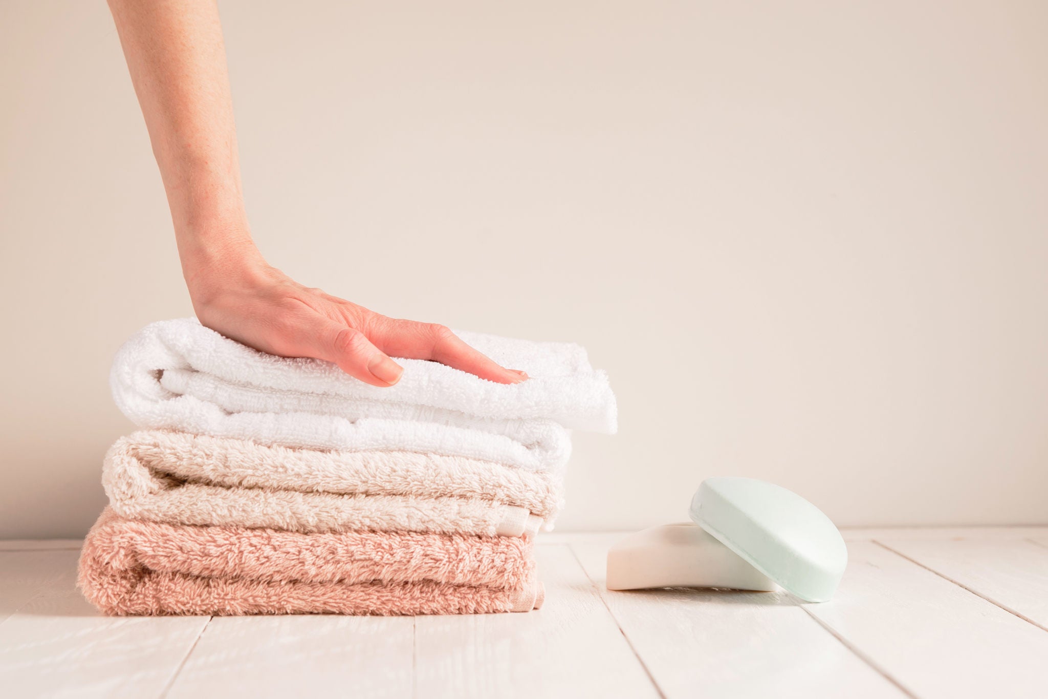 Woman's hand and a stack of soft towels