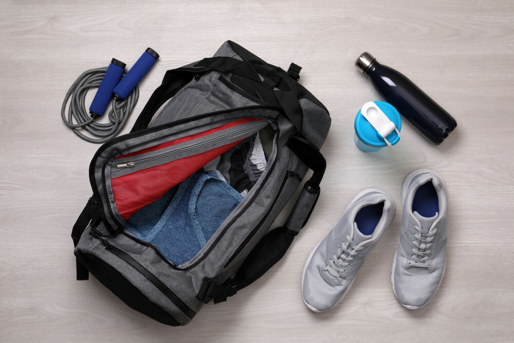 open black gym bag and gym essentials around