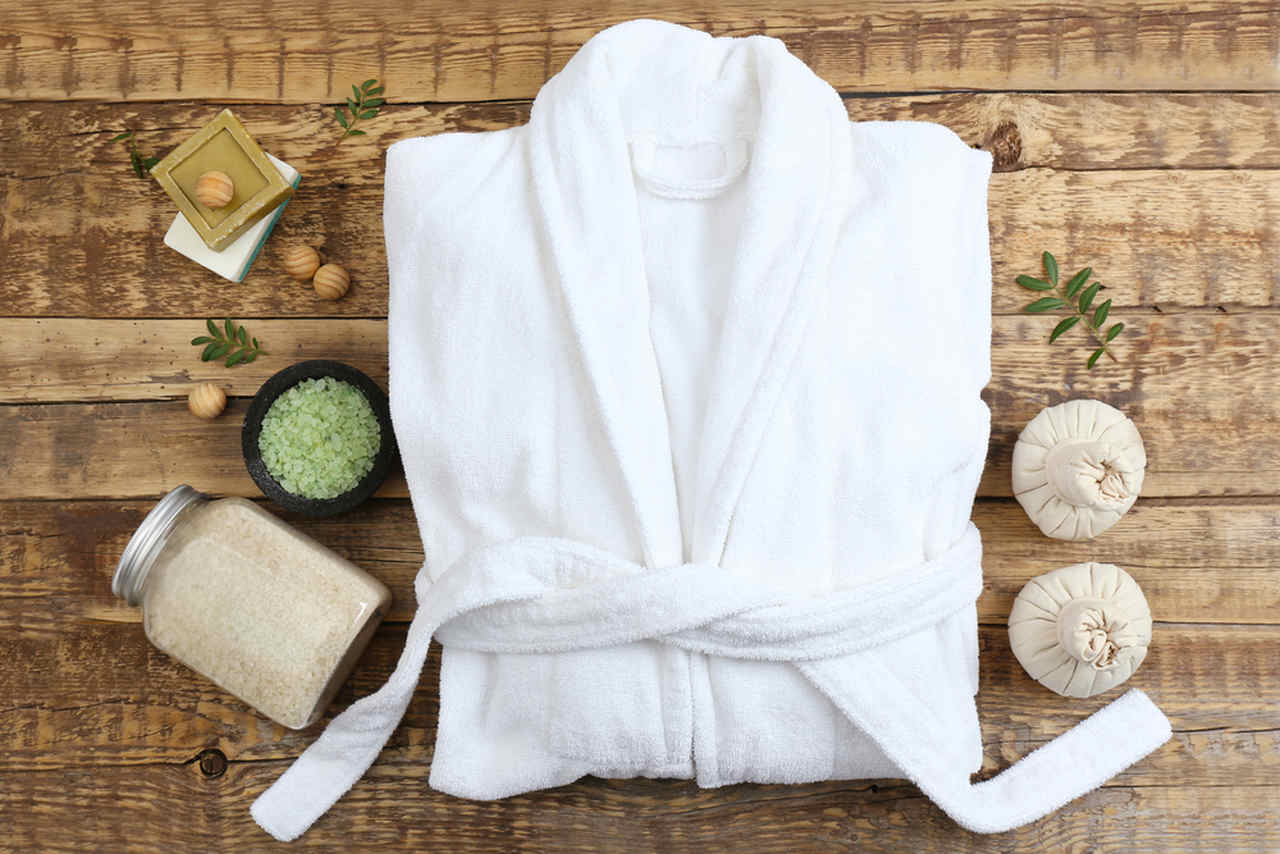 folded white spa robe with skin care products