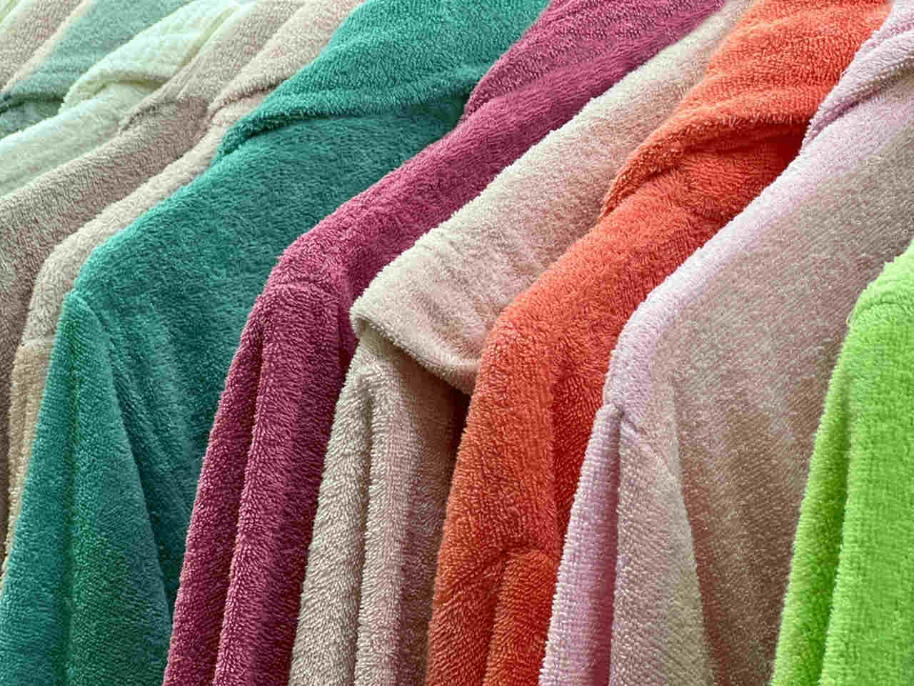 different colored plush bathrobes hanged in order