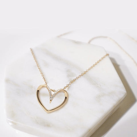 one of the awesome bridesmaid gift ideas is heart shaped necklace on the marble surface