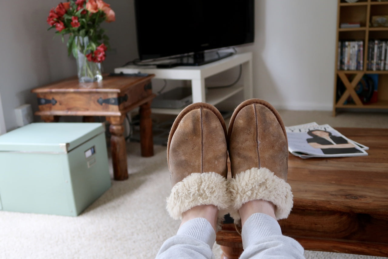 Raised women feet in suede slippers