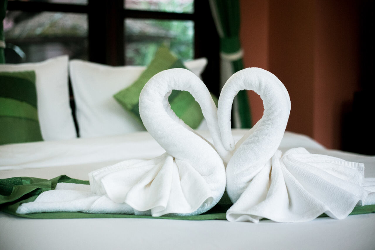 two swan shaped towels on a bed