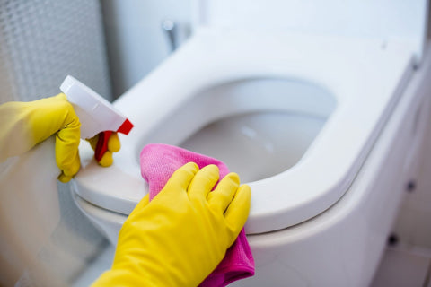a hand which wears gloves for cleaning the toilet