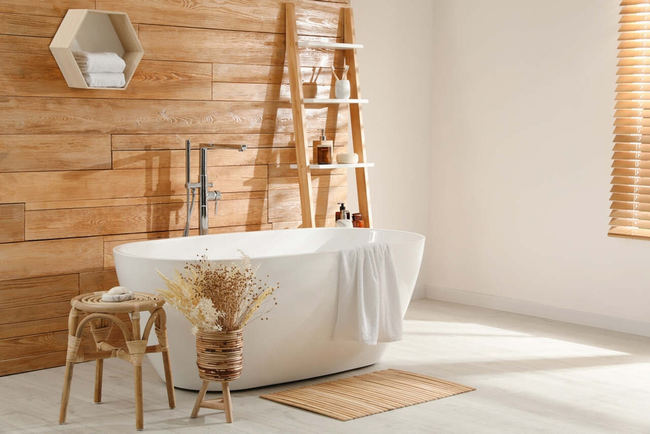 white bathtub with wooden texture on the wall