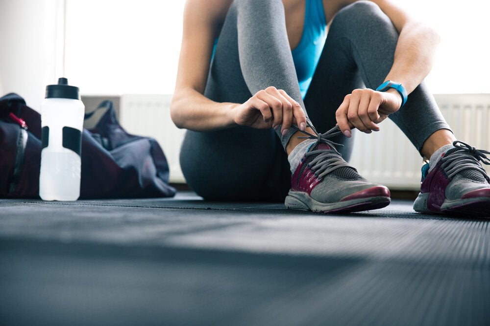 woman tying up a gym sneaker