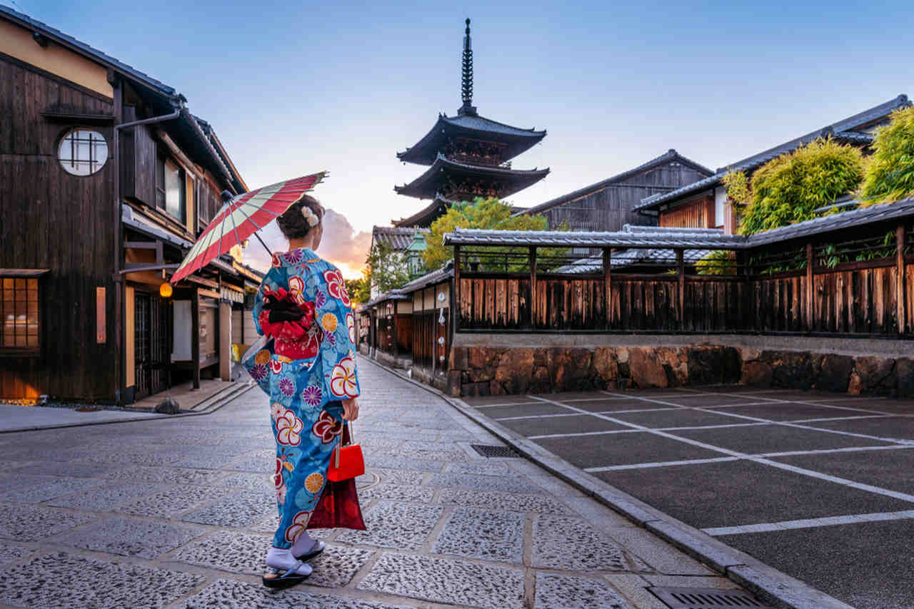 woman wearing a blue kimono and holding an umbrella