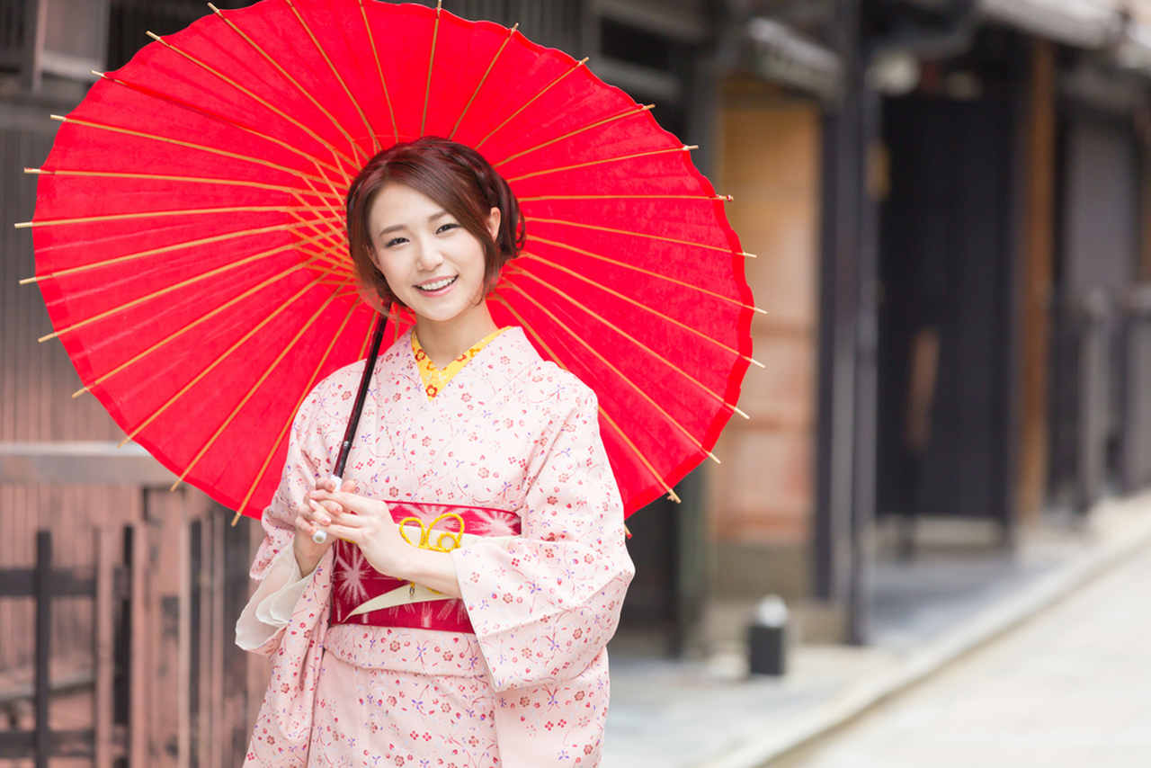 woman wearing white kimono and holding an umbrella