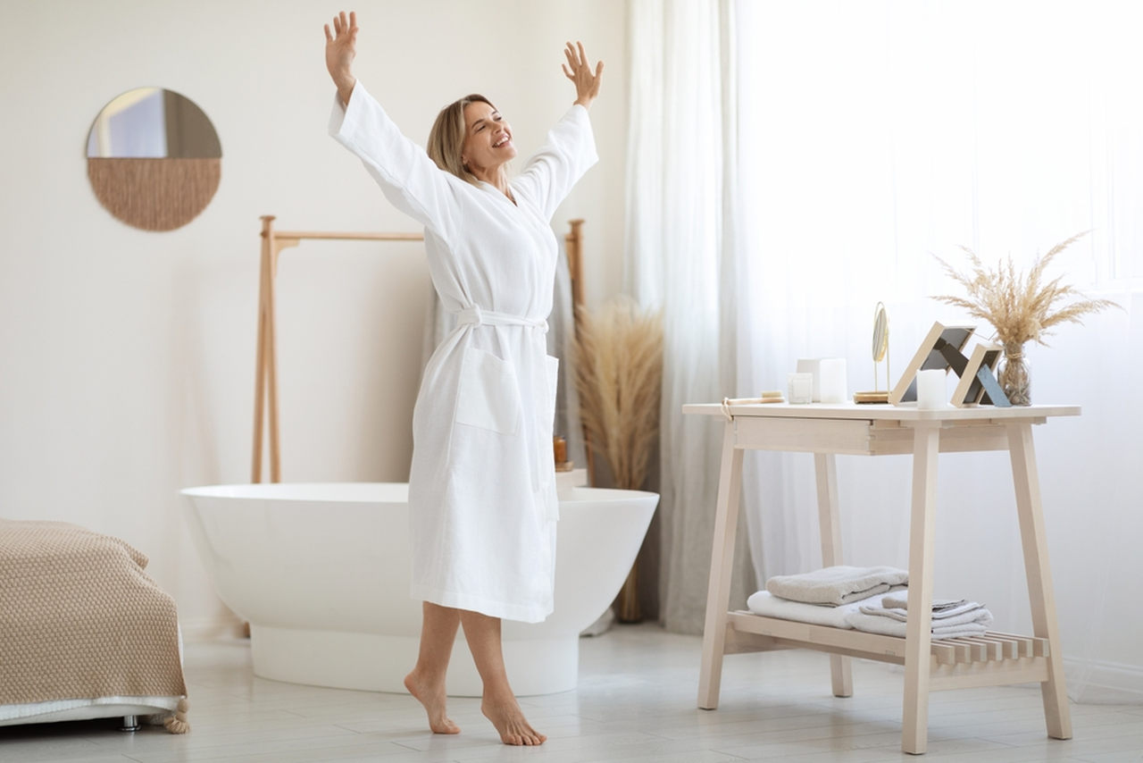 woman stretching while wearing a white spa robe