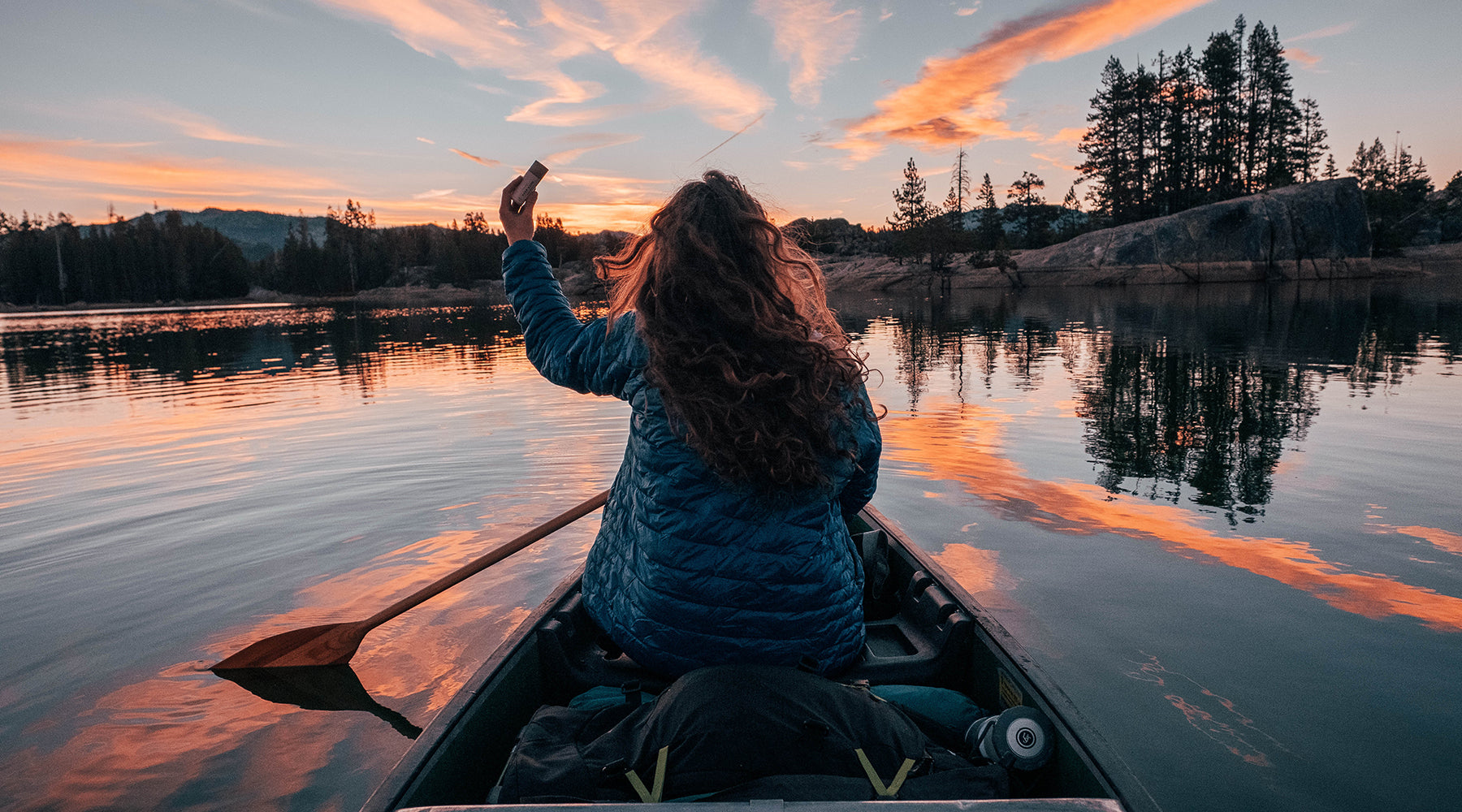 Woman on canoe at sunset holding Everkind deodorant.