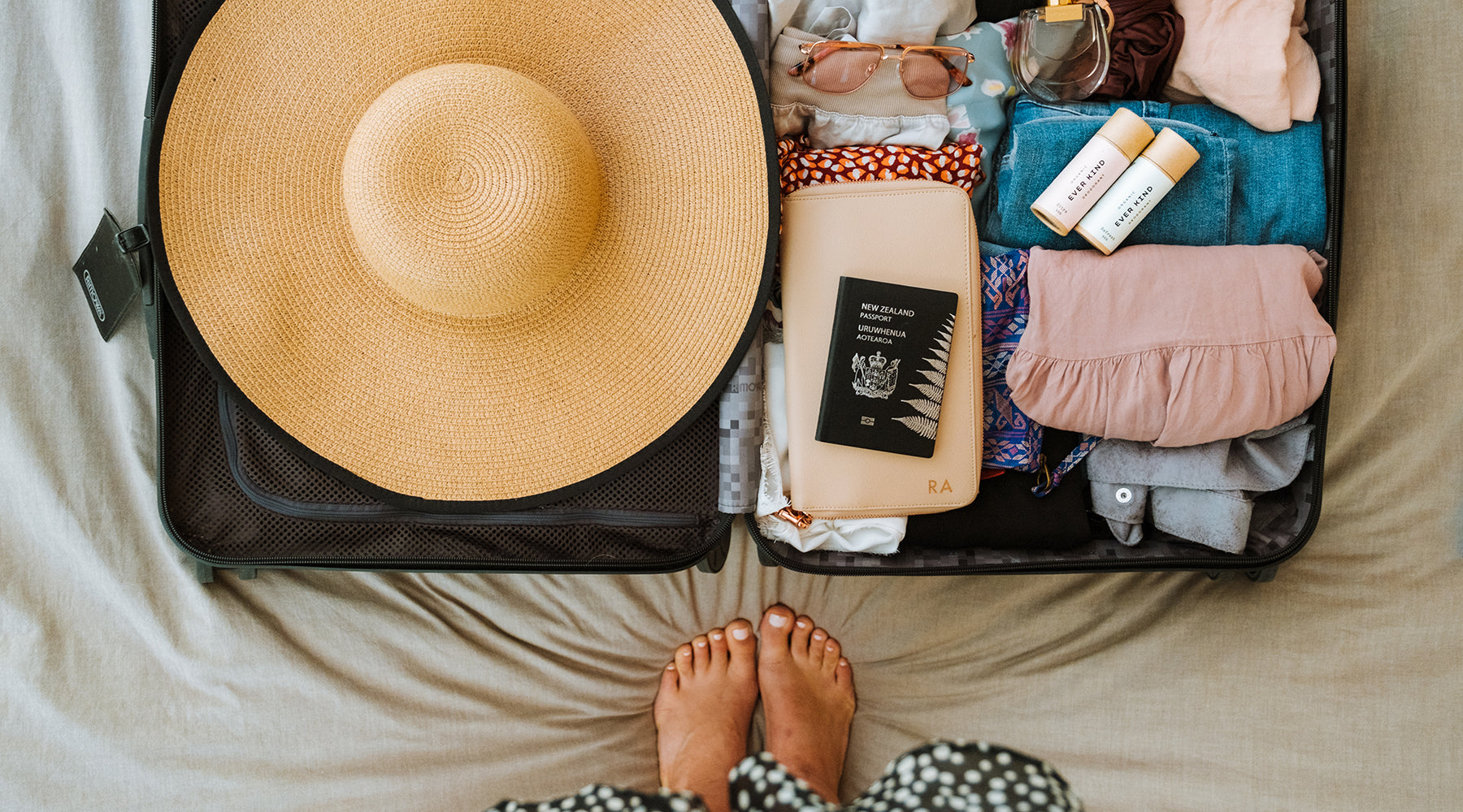 Suitcase packed with summer essentials, including Everkind deodorants.