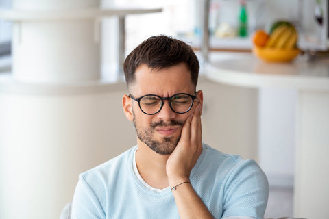 Man in pain from a cavity, experiencing soreness and discomfort from a toothache