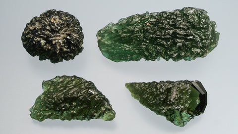 ic:Two moldavites from southern Bohemia, Czech Republic (top row) and two recent imitations from China (bottom row). The natural specimen on the top right measures 44 mm across. Photo by Jaroslav Hyršl