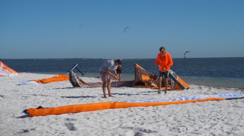 people on the beach preparing hydrofoiling equipment