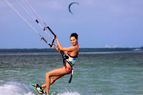 female in a bikini kiteboarding and smiling