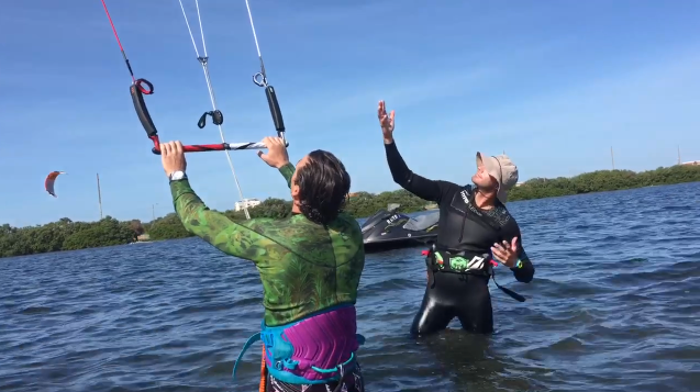 two people in the water learning how to kiteboard