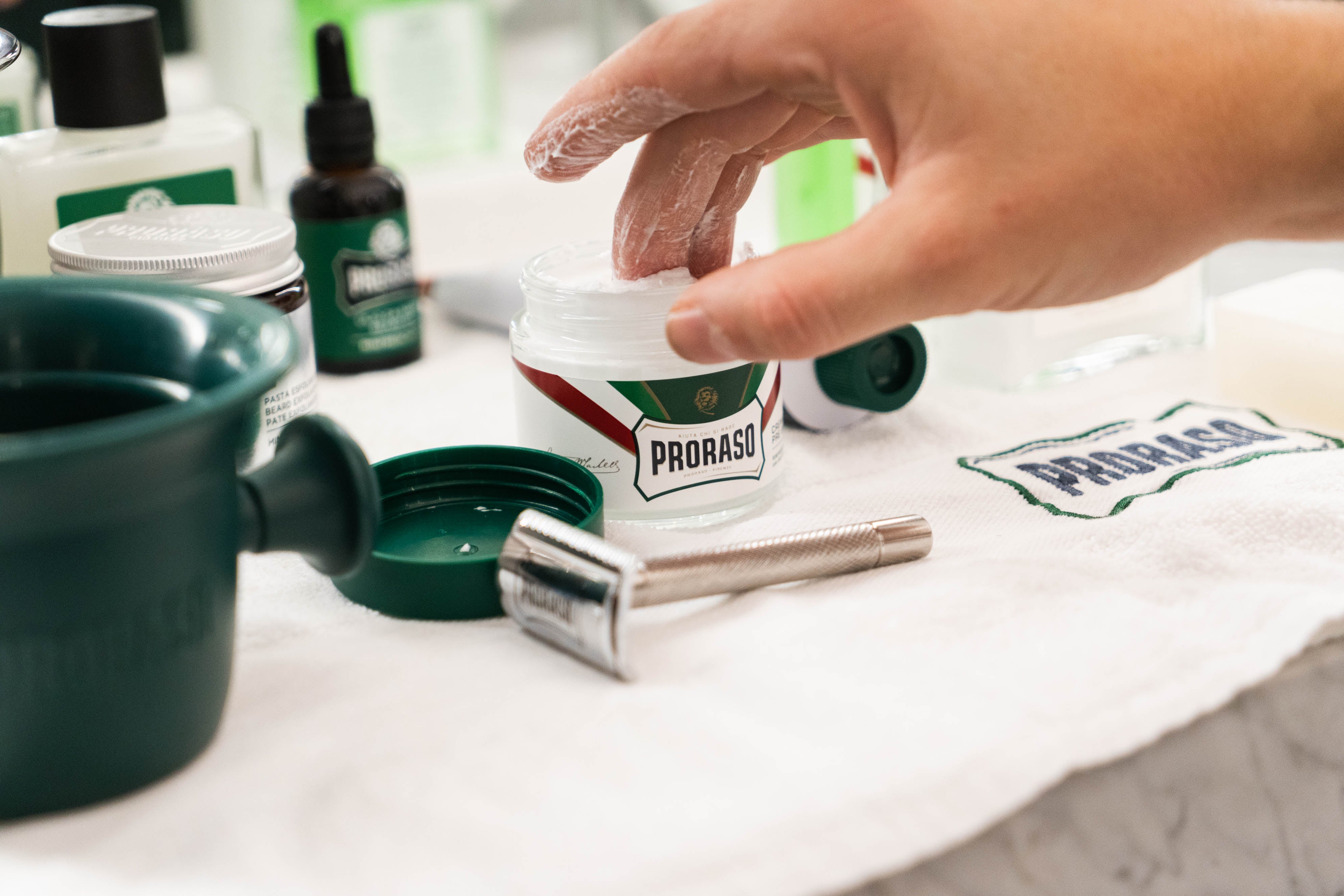 Barber scooping a dollop of Refresh Pre-Shave Cream out of a professional size jar