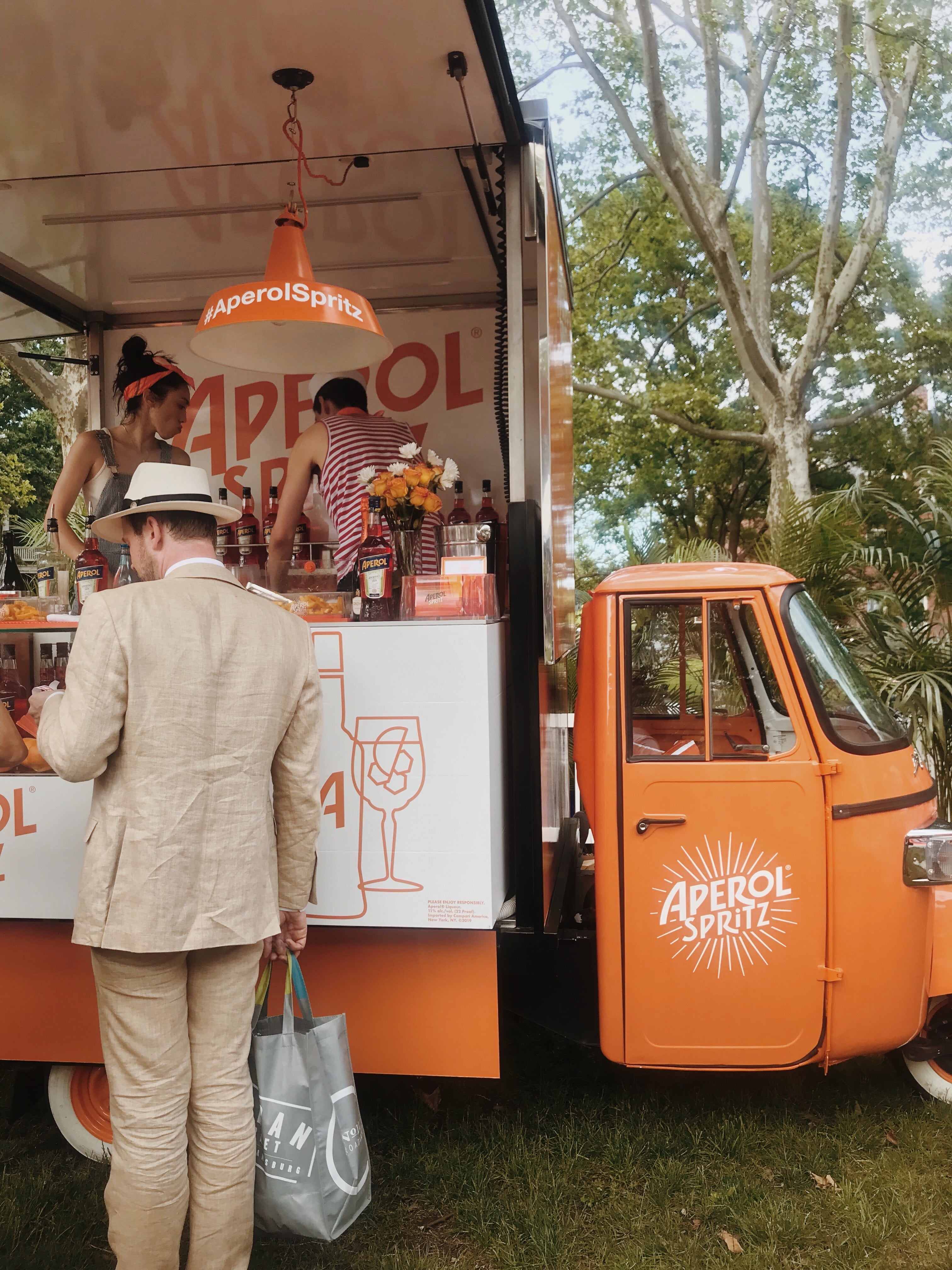 Man dressed in a vintage suit getting an Aperol Spritz at a mobile bar