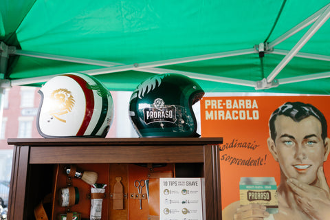 Image of the Proraso booth at the Distinguished Gentleman's Ride- two motorcycle helmets on top of a bookcase with Proraso product on the shelves  