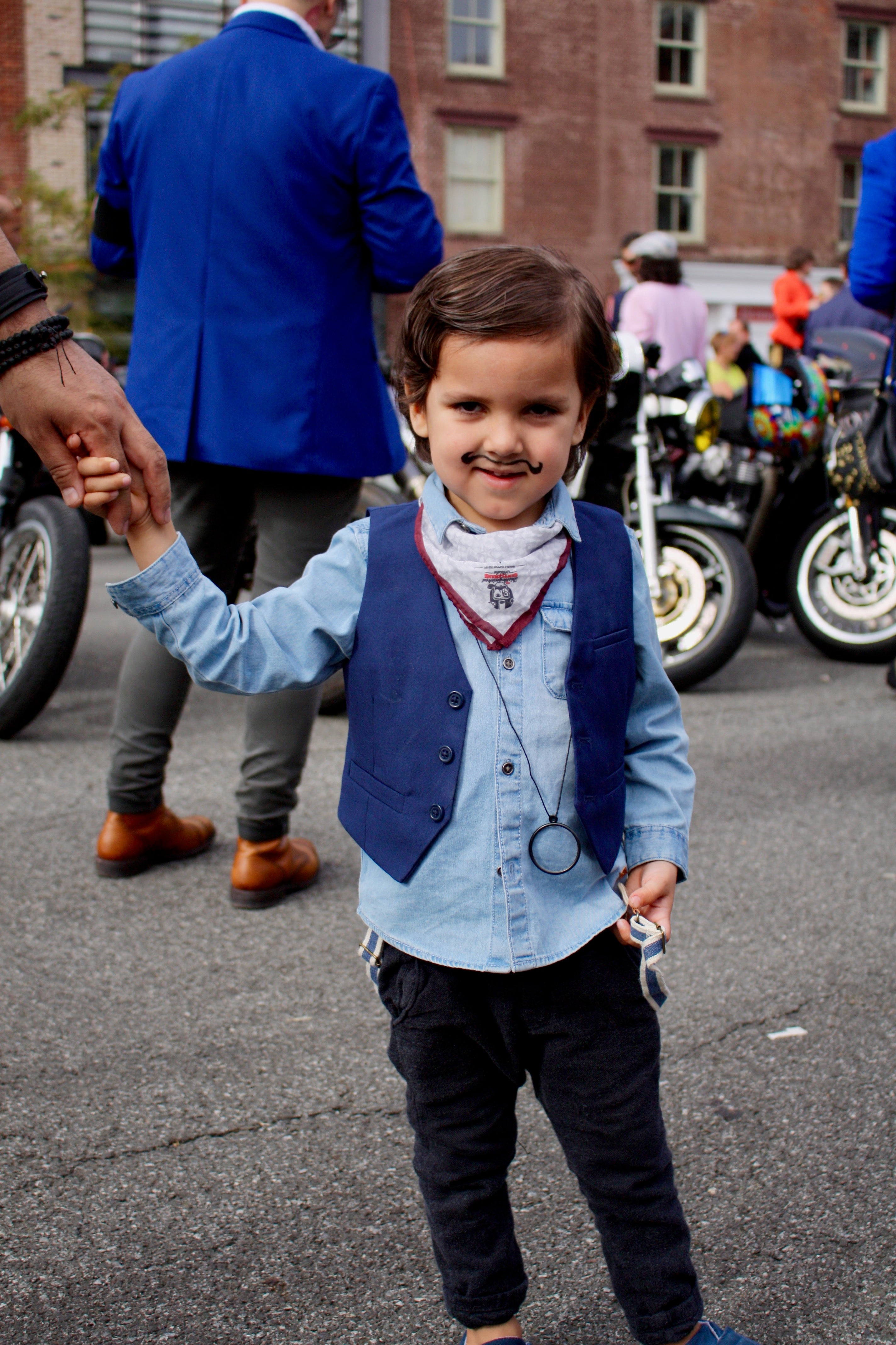 Tolder dressed in vintage clothing holding his dad's hand posing for the camera