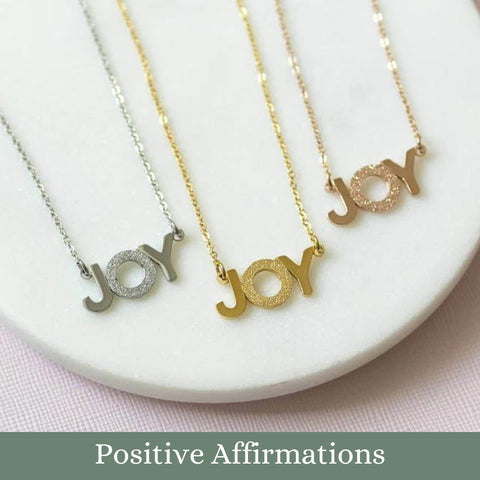 Image shows JOY positive affirmation necklace available in three colours