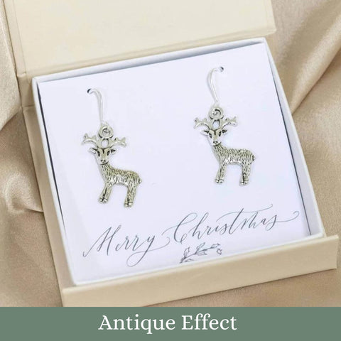 Image shows antique effect Christmas Reindeer earrings on a white 'Merry Christmas' sentiment card