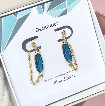 Image shows Oval birthstone charm earrings with the december birthstone