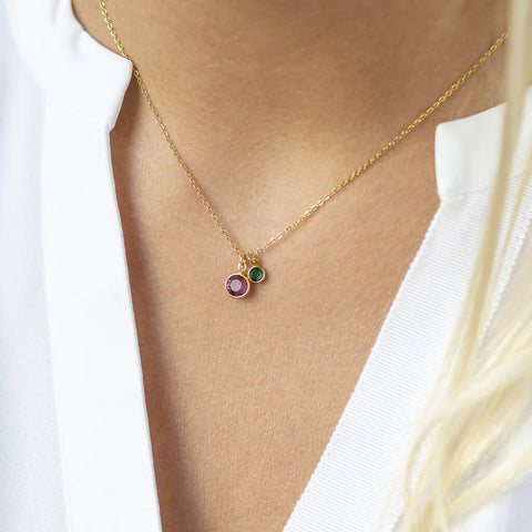Model wears mother and child birthstone charm necklace with Swarovski birthstones: February amethyts to represent mum, and May emerald to represent child.