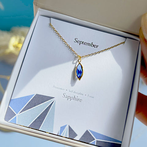 Image shows boxed marquise birthstone necklace in september sapphire