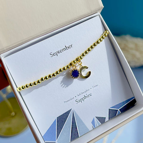 Image shows boxed stretch initial birthstone bracelet in september sapphire with the initial 'c'