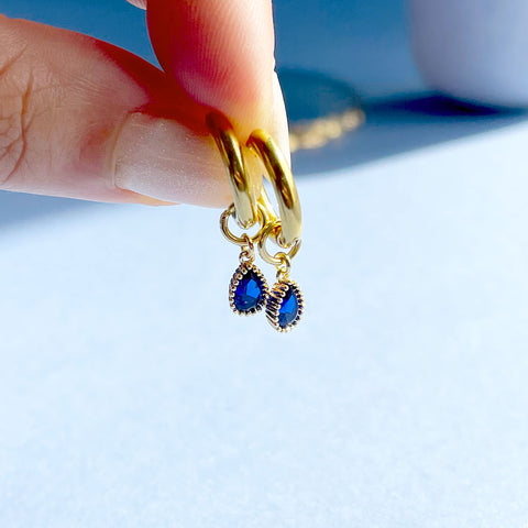 Image shows gold plated hoop earrings with september sapphire teardrop birthstones