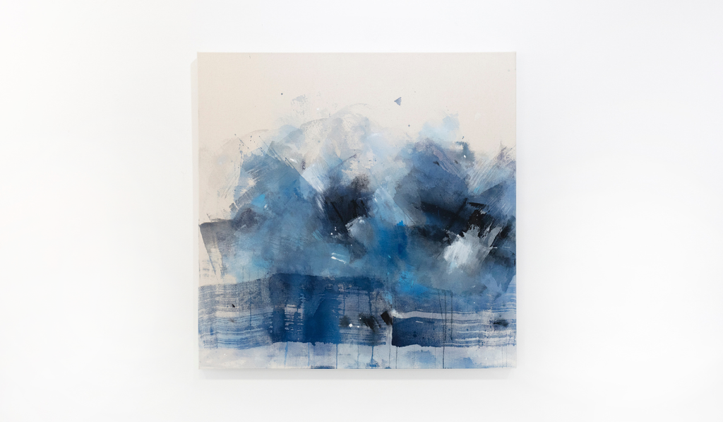 A blue abstract painting hangs on a white wall.