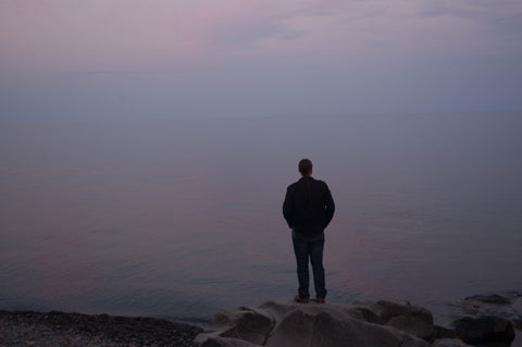 Erik stands, facing East, looking over Lake Superior.