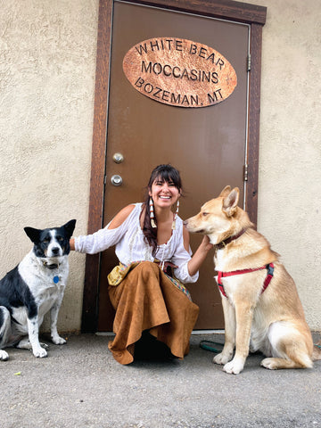 Shauna White Bear and her two dogs sit outside the door to her studio in Bozeman, MT