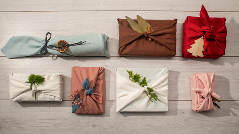 presents wrapped in furoshiki with decorative natural materials tied into them