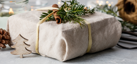 present wrapped in cloth, decorated with cinnamon and branches