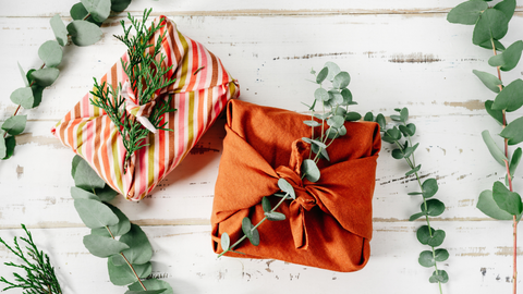 gifts wrapped in cloth with twigs tied into them as decoration