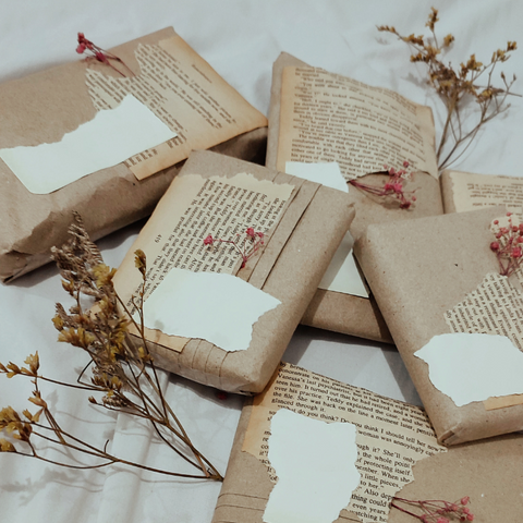 presents wrapped in kraft paper layered with torn book pages and paper scraps