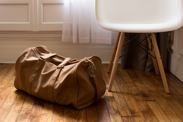 A packed brown canvas duffle bag
