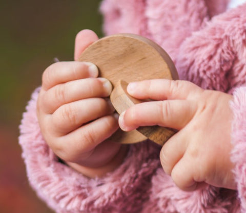 baby holding interlocking discs