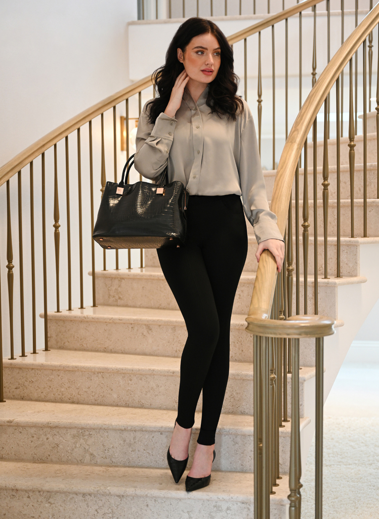 Woman stands on stairs in office attire, wearing the Black Treggings by LOVALL.