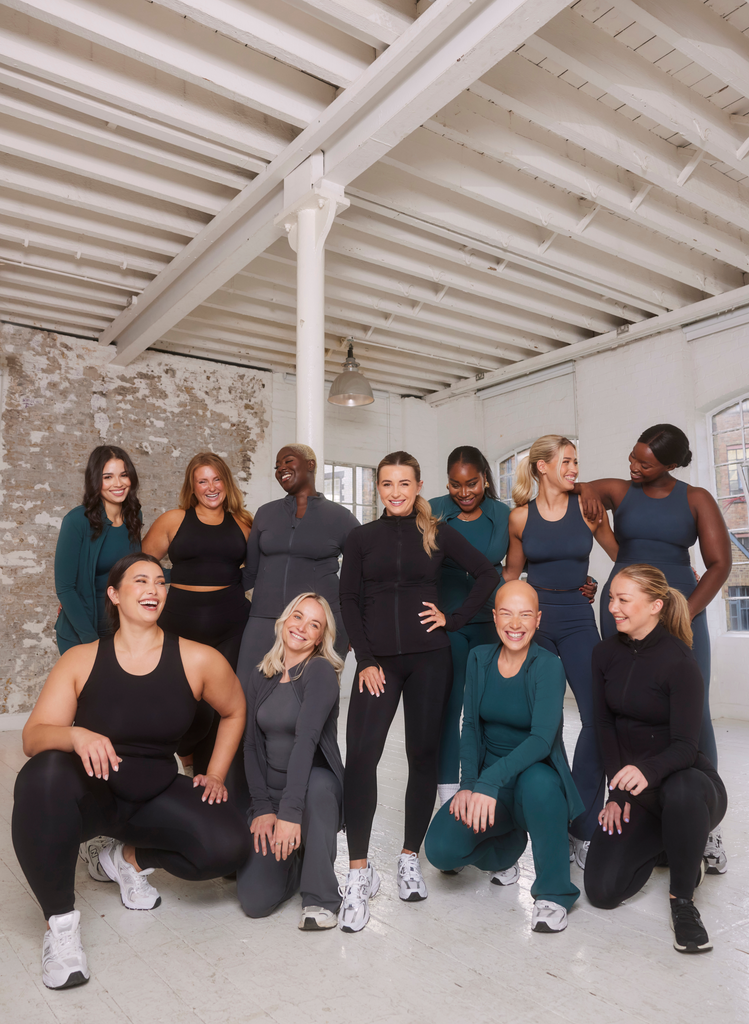 A group of women of all sizes, ethnicities, abilities, and heights, stand together looking beautiful. They are all wearing different versions of the Empower Collection by LOVALL.