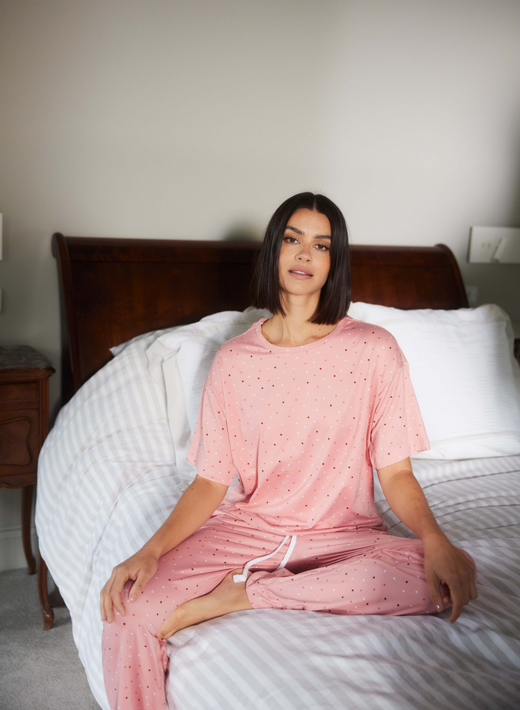 Model wears the Pink Dot Soft Touch Pyjamas in her bedroom.