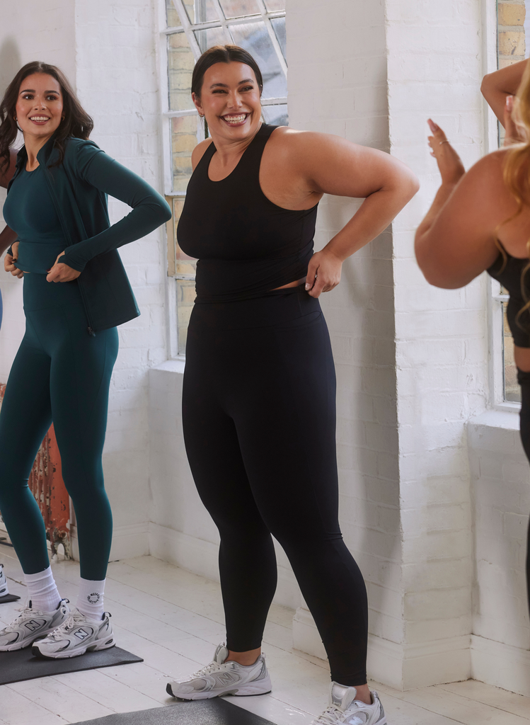 Woman wears Curve Empower gym wear set in black.