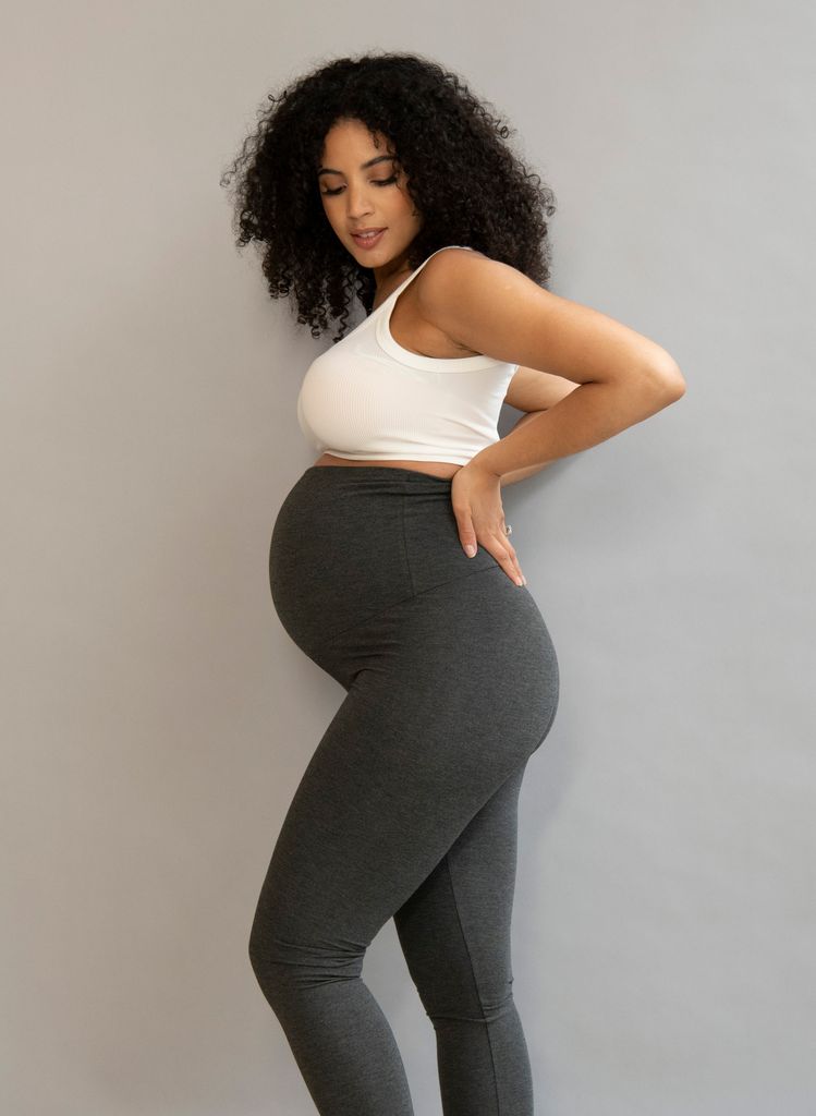 Woman wears the Maternity Everyday Leggings in Dark Grey, standing in a studio.