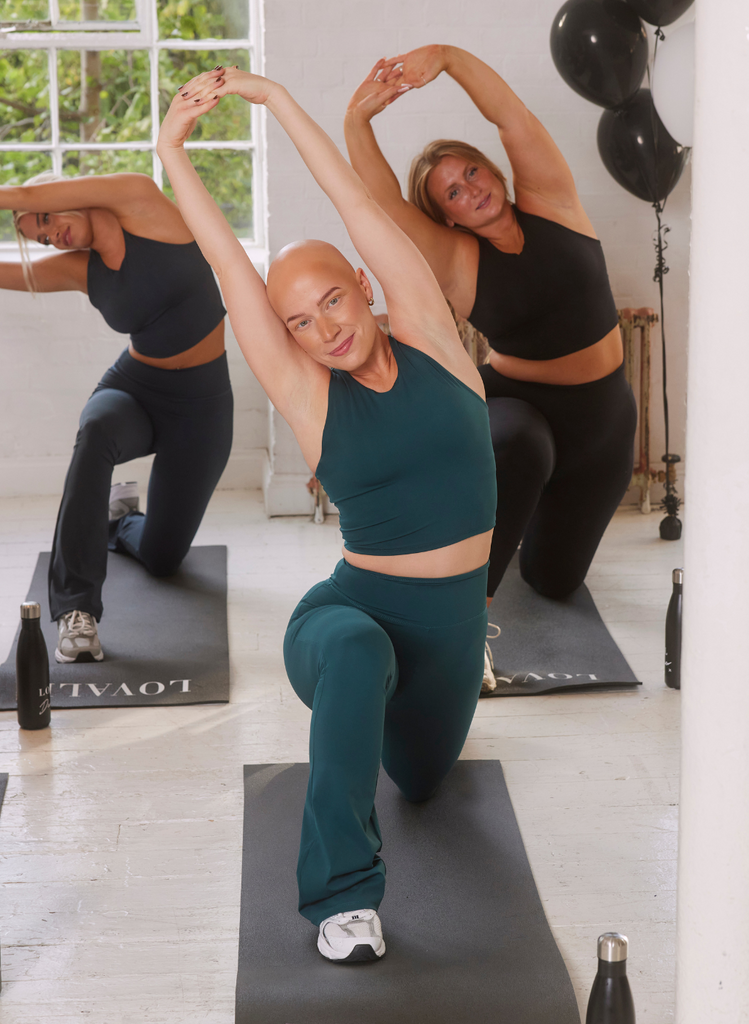 Women take part in a yoga class, on LOVALL yoga mats and wear variations of the Empower Set by LOVALL.