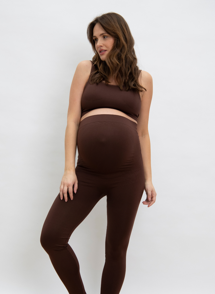Woman wears Maternity Seamless Set in Chocolate Brown, against a white backdrop.