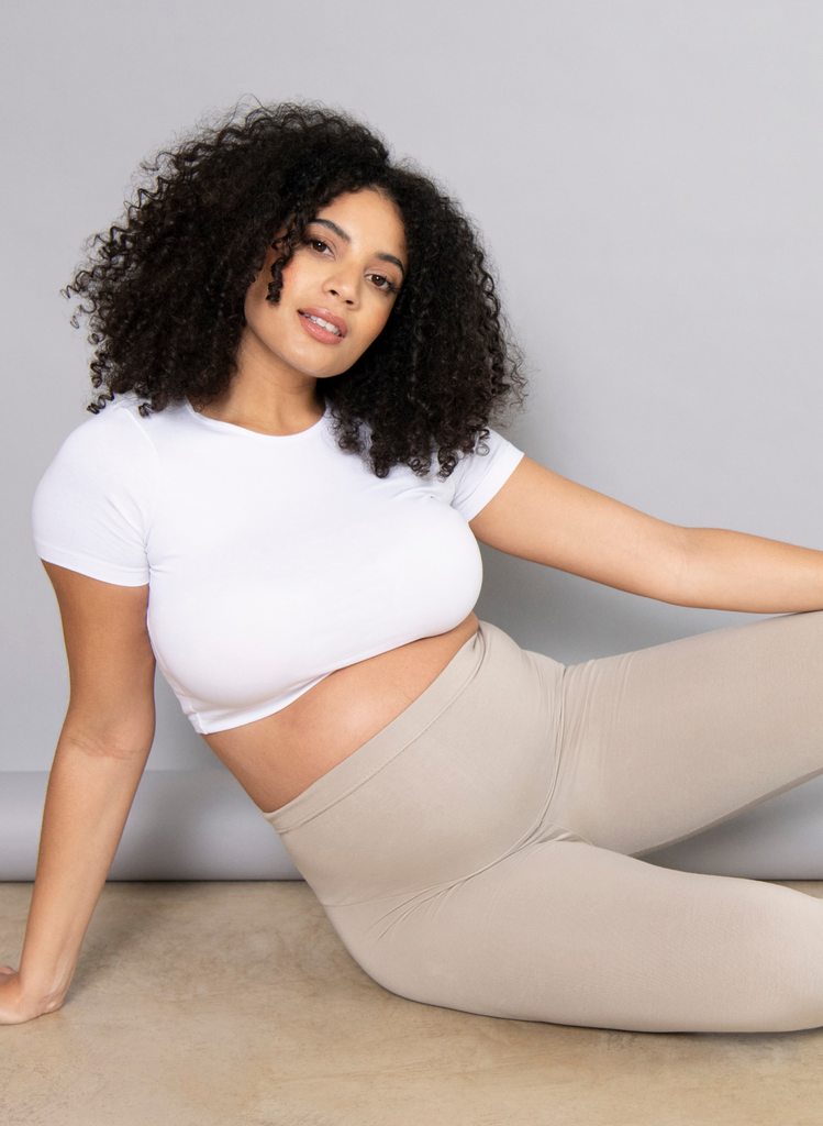 Woman wears Oatmeal Beige Everyday Maternity Leggings with white cropped top.