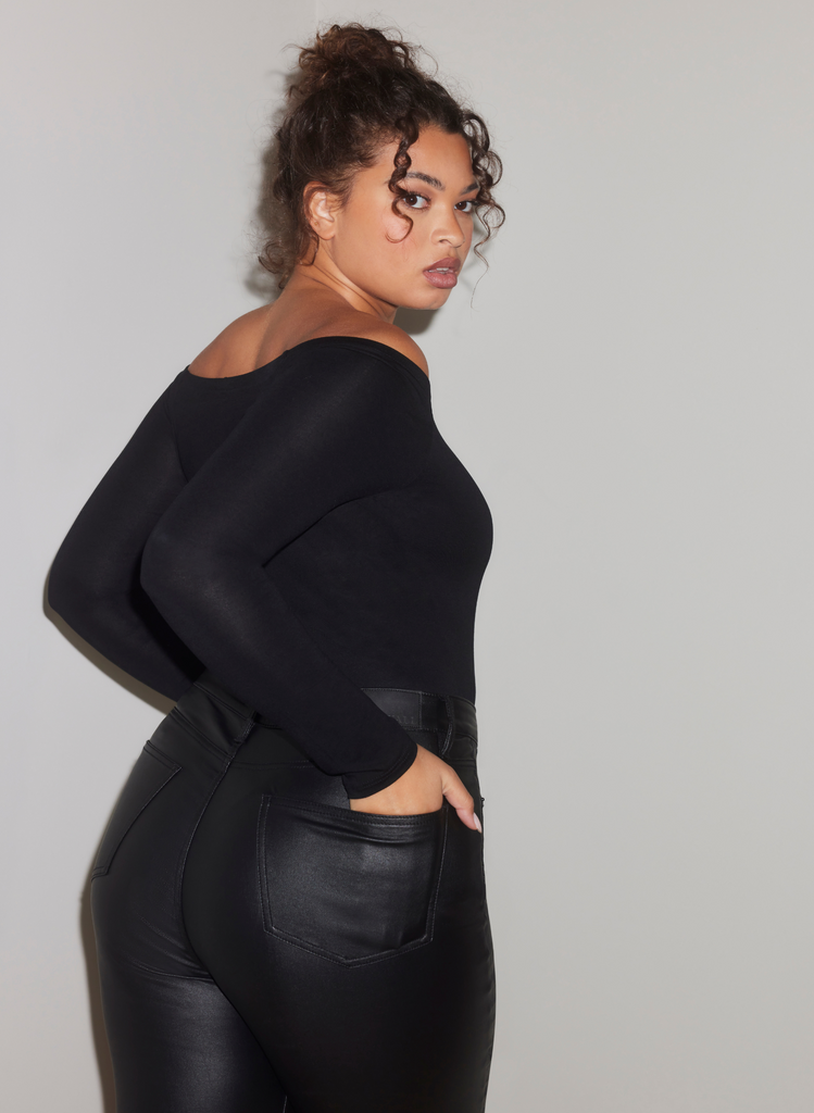 Woman wears Coated Jeans with Black off-the-shoulder leotard.