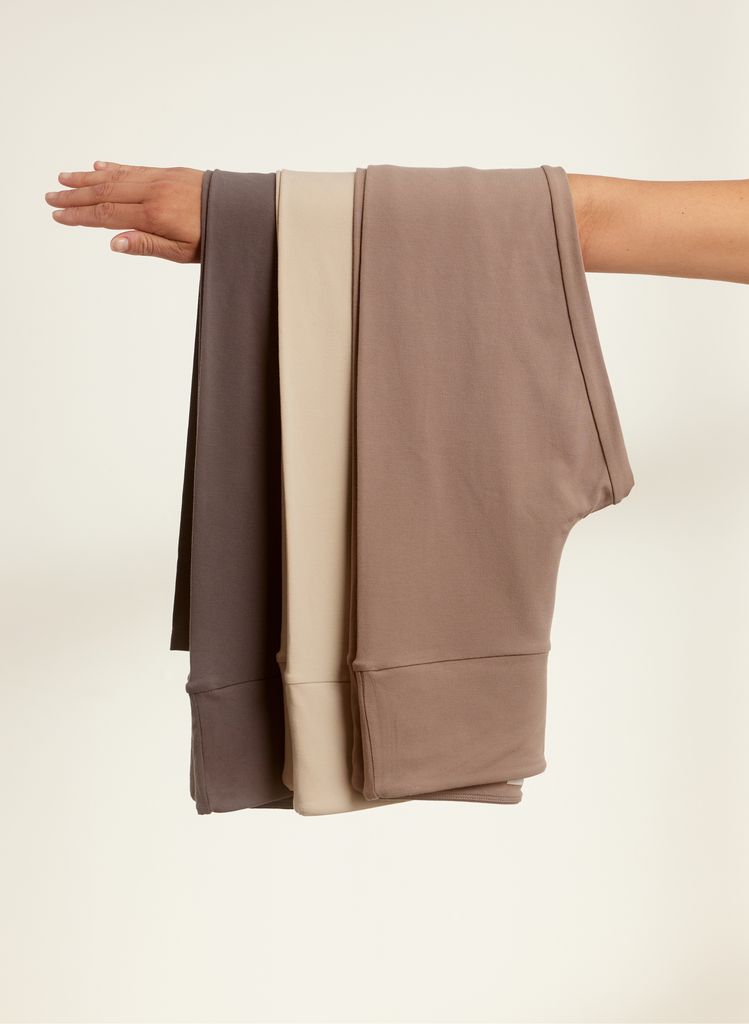 Variations of Beige Leggings hung over a woman's arm.